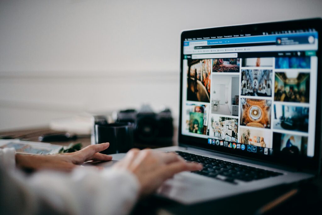 Person using laptop, with the screen showing several different images.