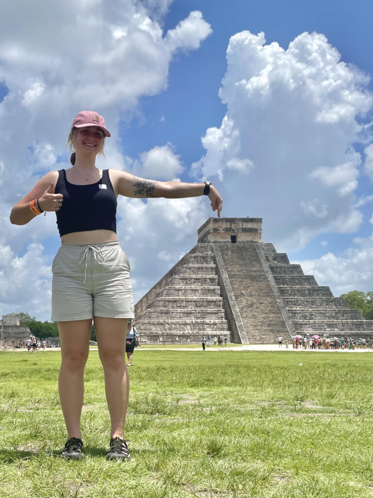 Photo of author posing with the Chichen Itza temple in Mexico