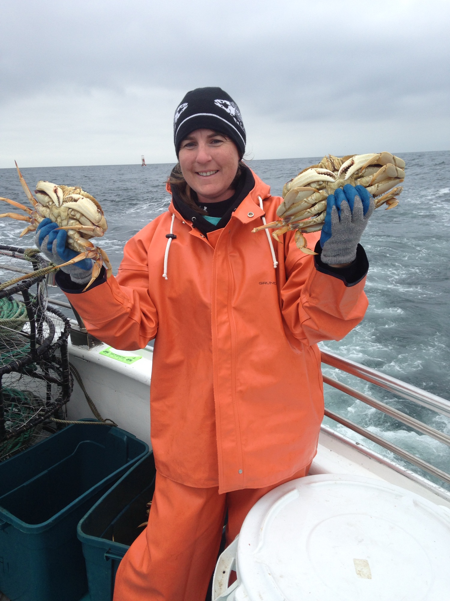 Lori holding up two dungeness creabs